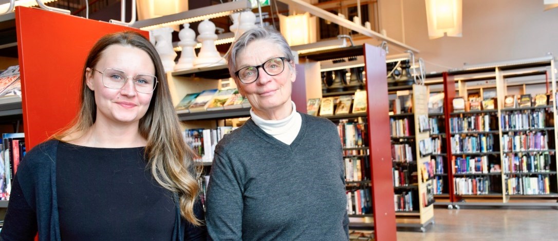 Linnéa Blomqvist och Ann-Britt Dahl står i biblioteket. 