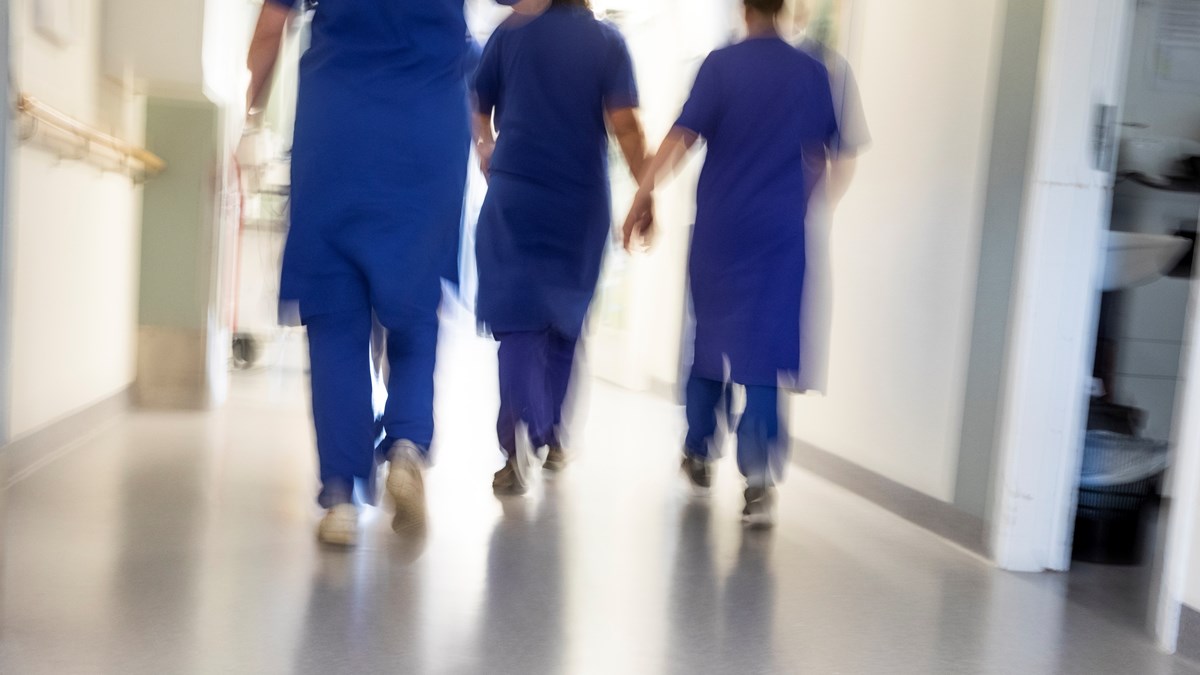 Sjukhuspersonal går i en korridor. Bilden är suddig. 