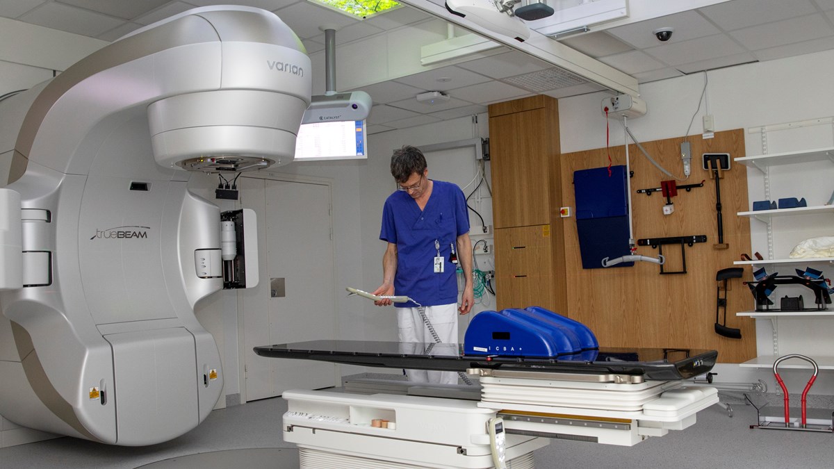 Blåklädd personal i ett rum avsett för strålbehandling av patienter
