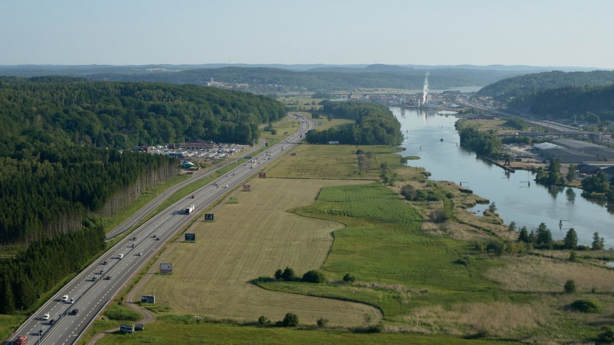 Drönarbild över jordbruksmark mellan väg och vattenled trafik 