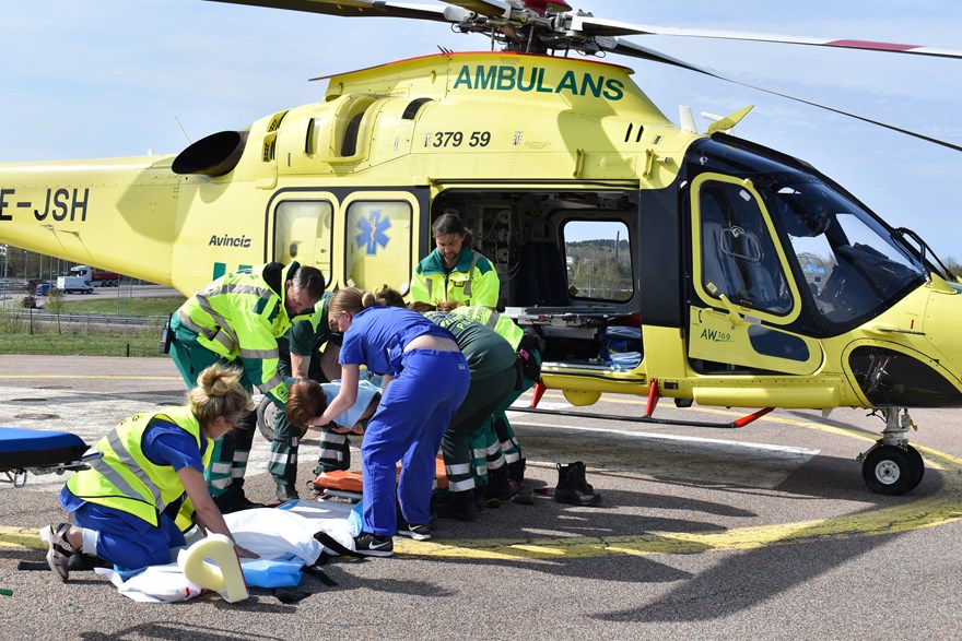 ambulanshelikopter, sjukvårdspersonal och patient.
